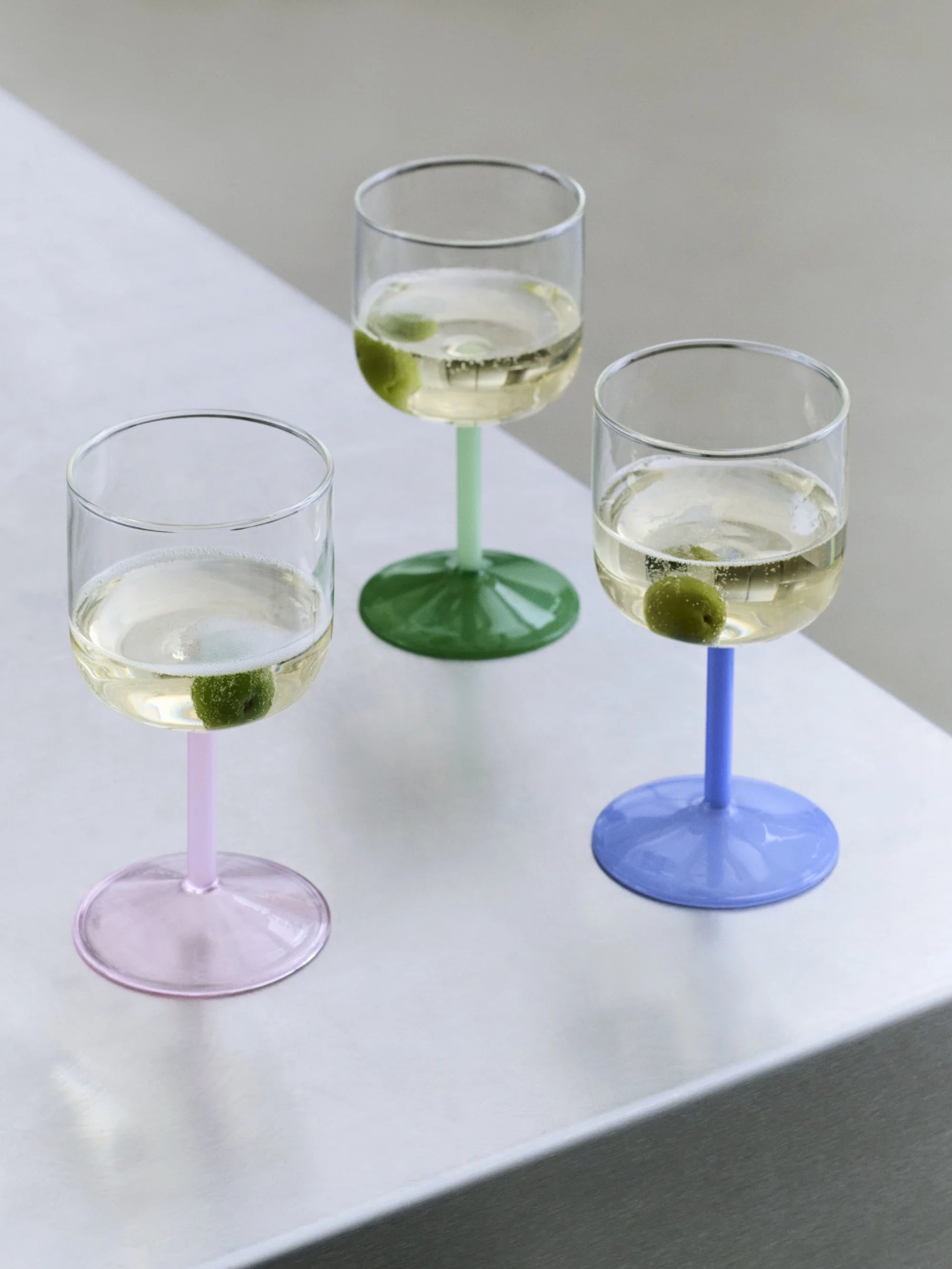 Hay wine glasses on a white table