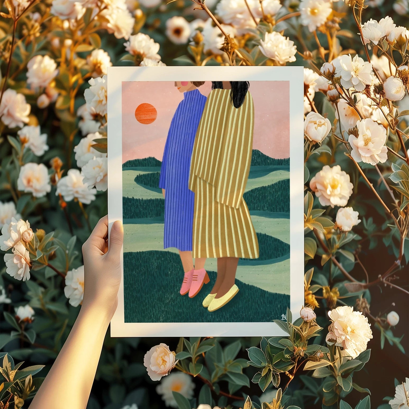 Bea Müller 'Friends With Striped Dresses' A3 Unframed Art Print being held up in front of a wild rose bush