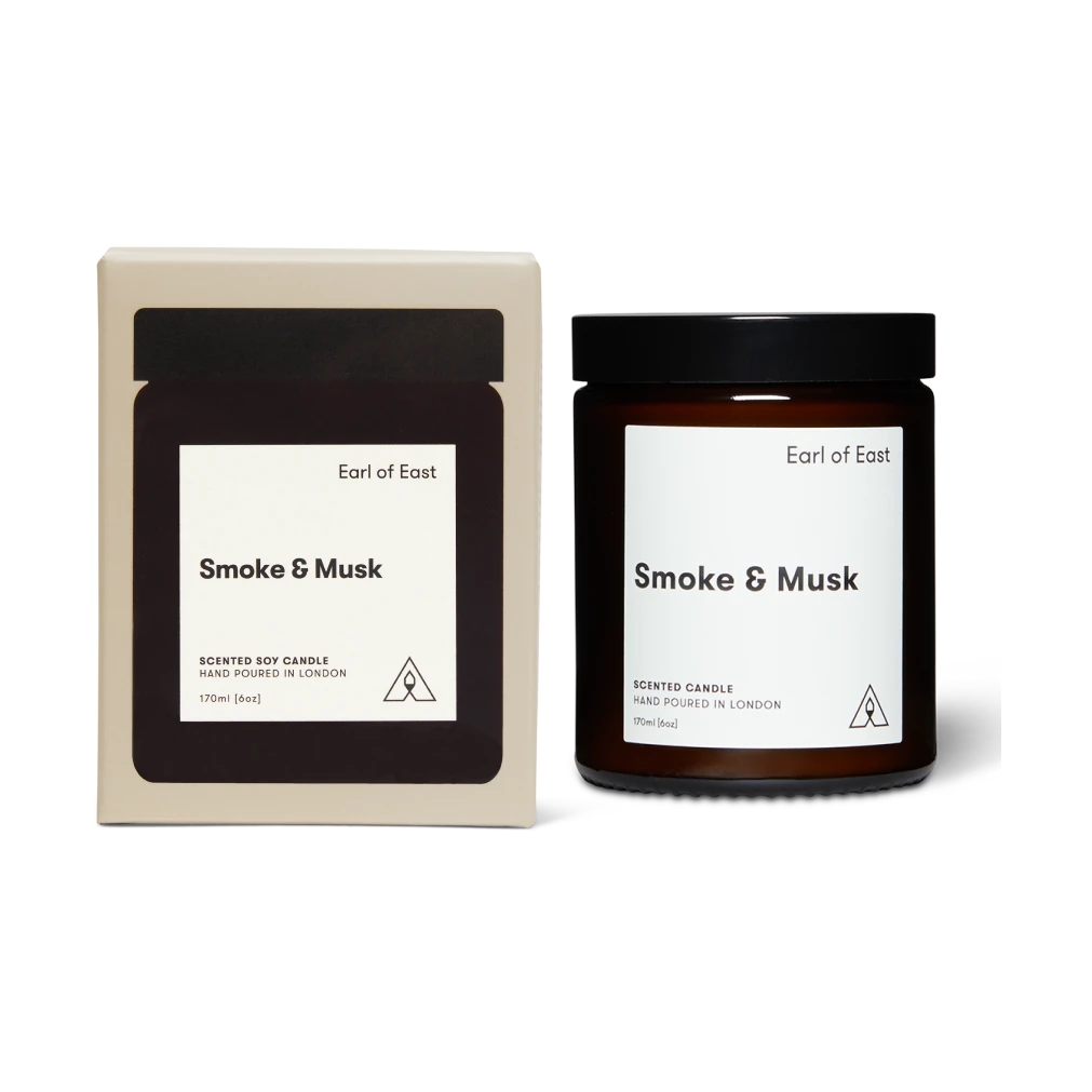 Candle and packaging labeled 'Smoke & Musk' by Earl of East on a white background