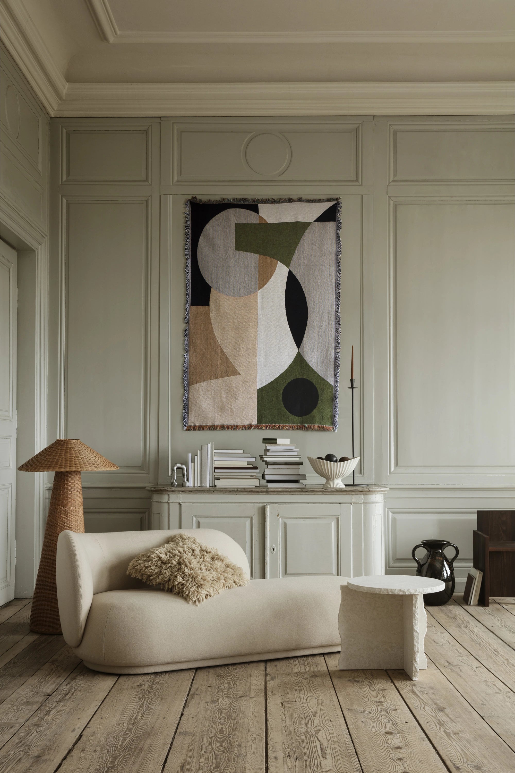 Ferm Living Rico Divan with a left situated backrest in off white next to the Mineral Sculptural table and Entire Tapestry blanket