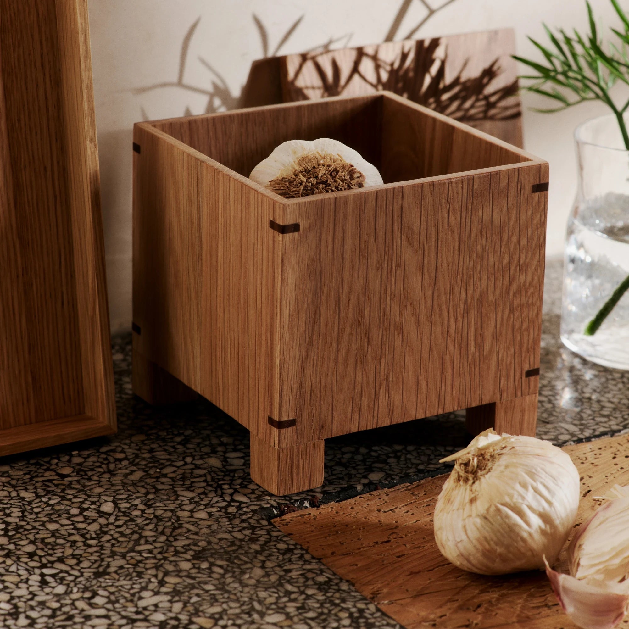 Ferm Living Bon Garlic Box in Natural Oak in context with garlic inside and next to the box