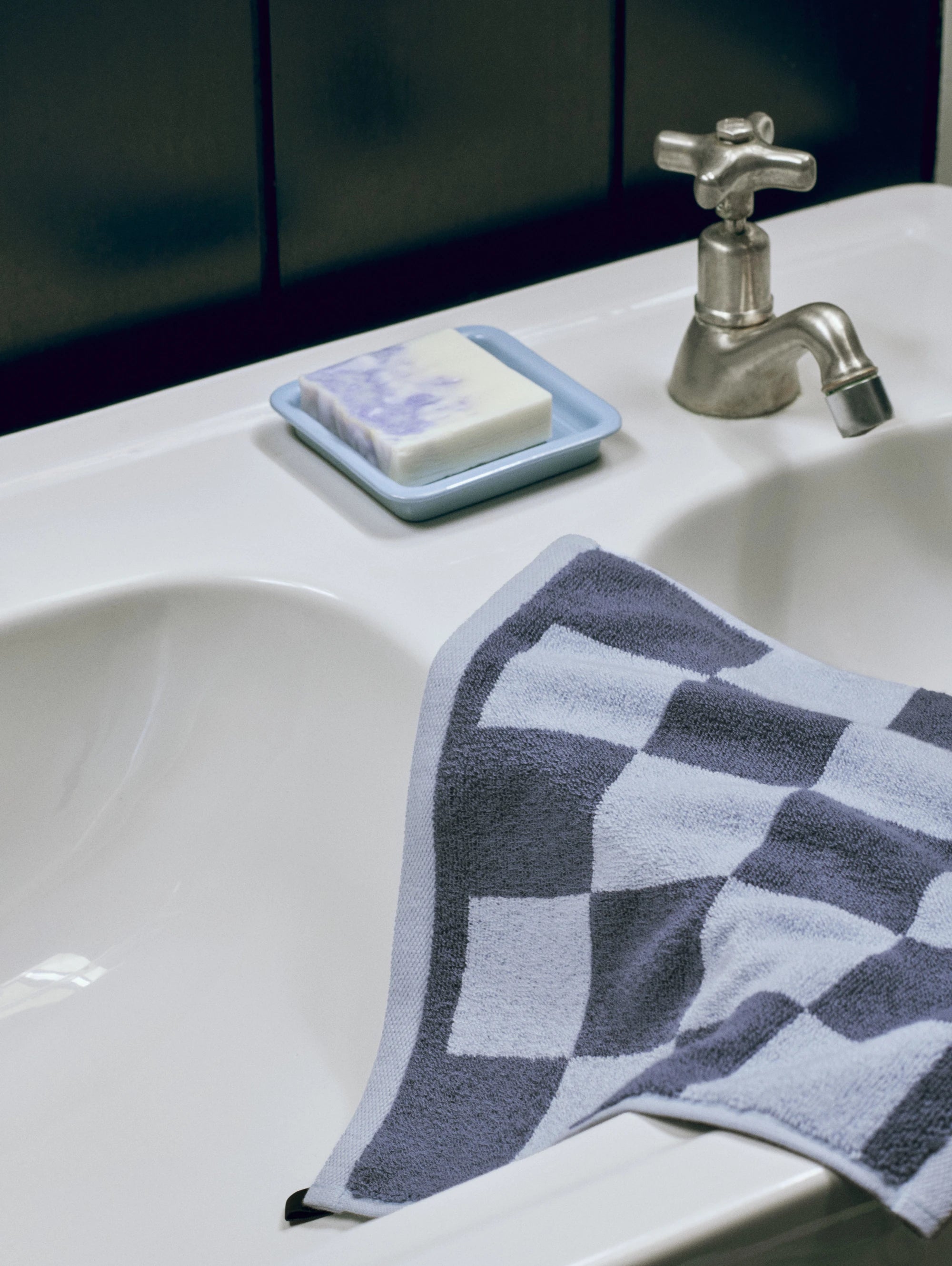 HAY Organic Cotton Check Wash Cloth on steel blue lying on the side of a sink next to the HAY soap dish