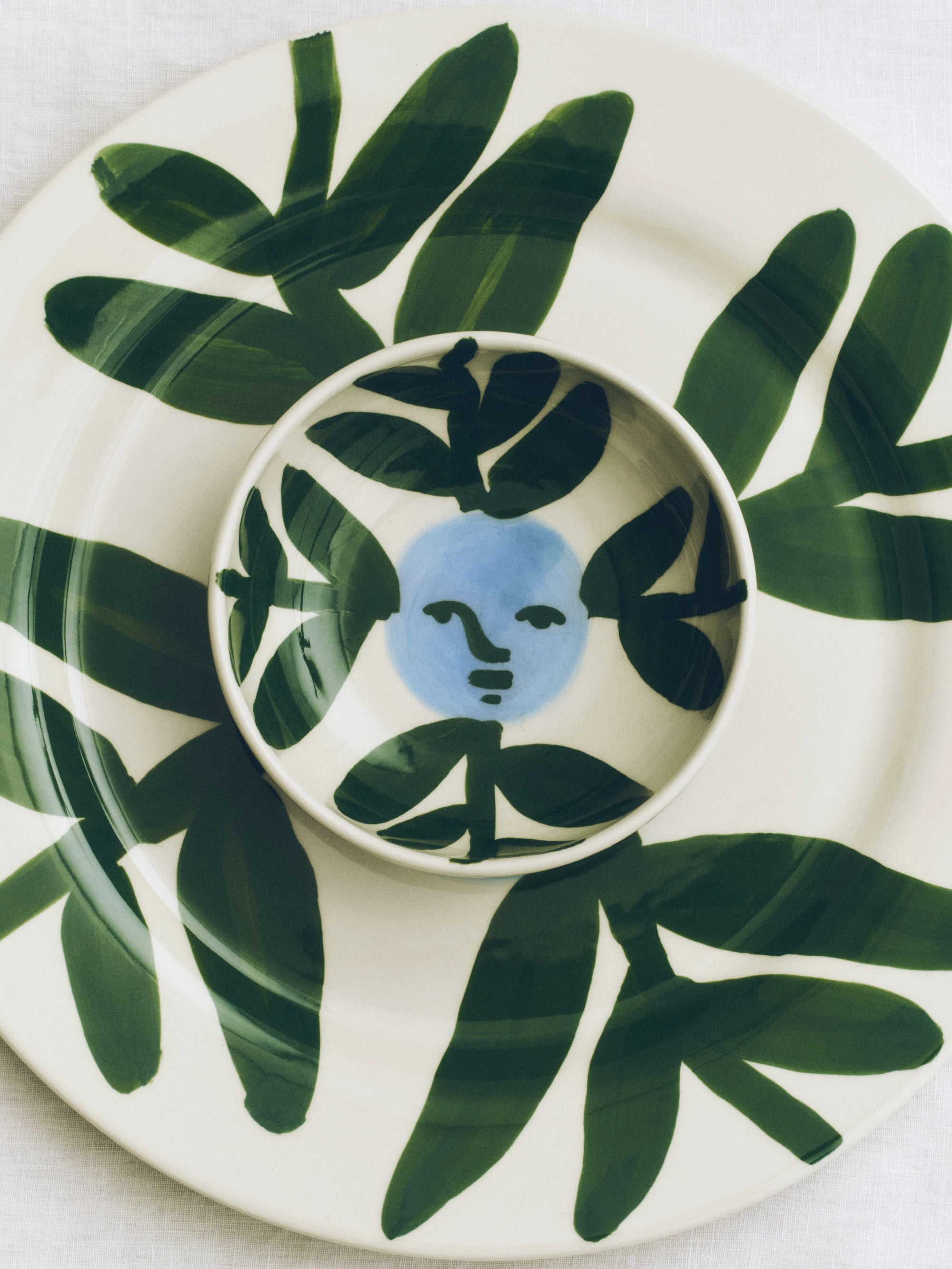 HAY x Emma Kohlmann - La Pittura Moon Face Vine bowl atop the plate