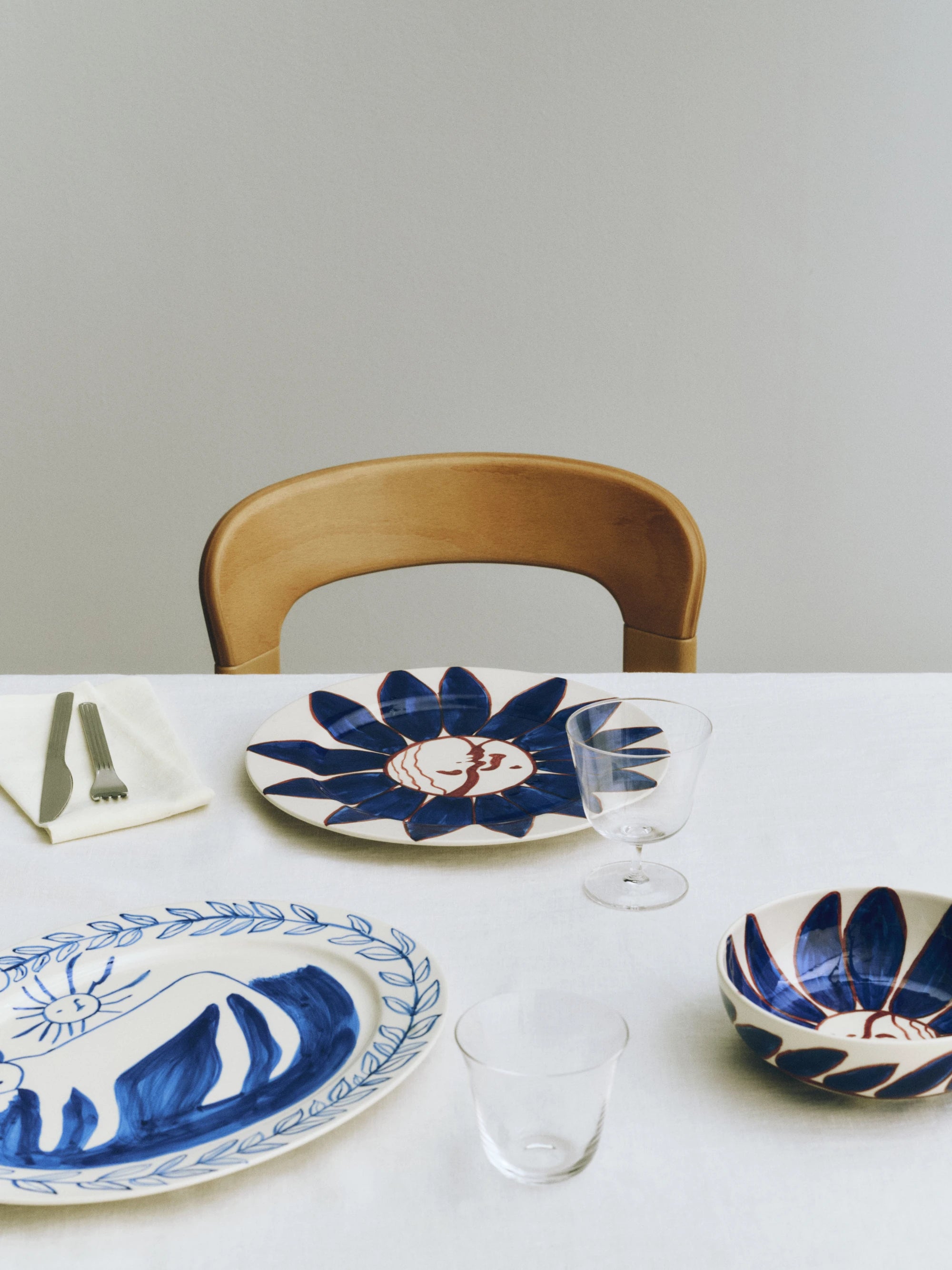 HAY x Emma Kohlmann - La Pittura Deep Blue Flower plate and bowl on a tableclothed table with glassware and cutlery
