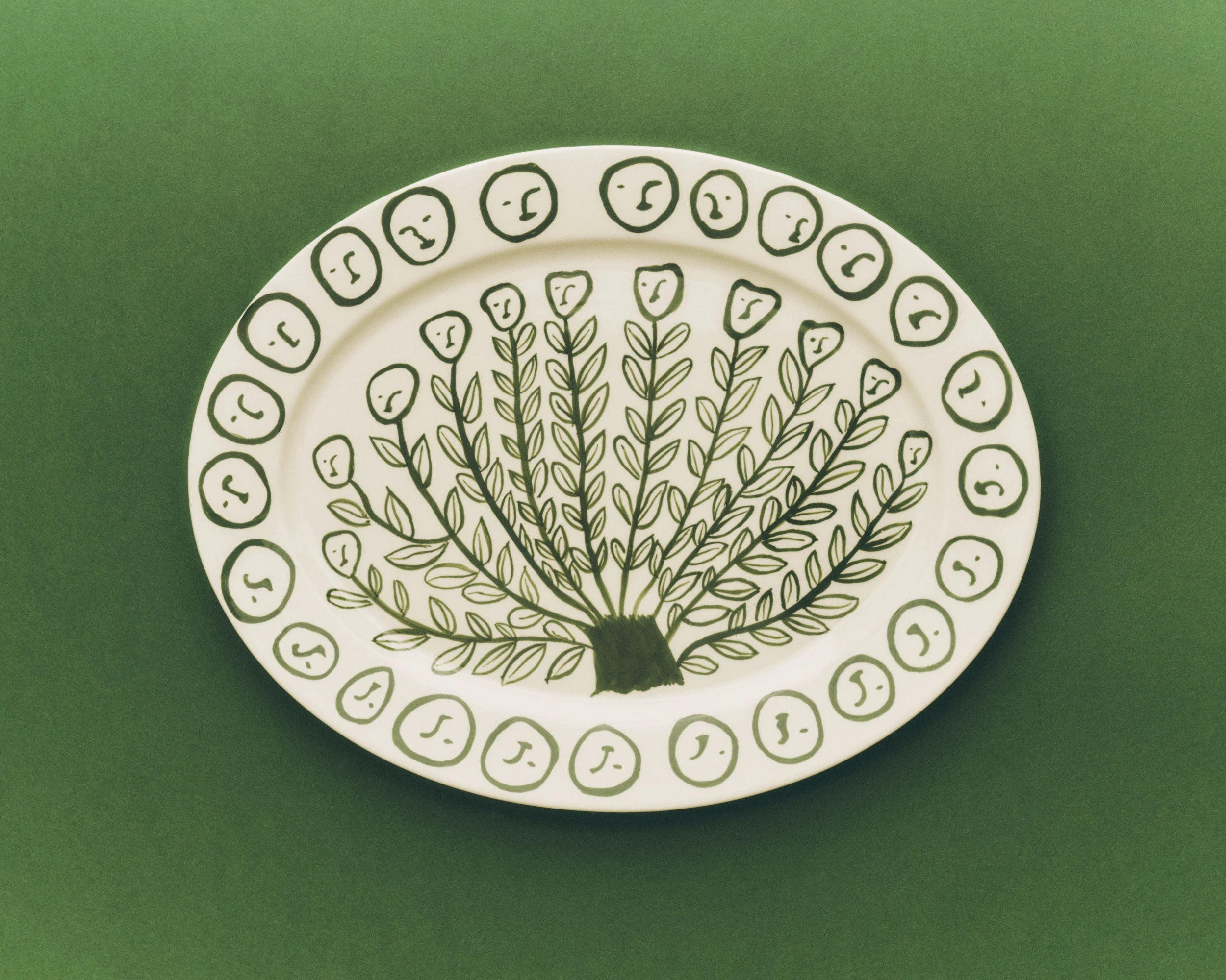 HAY x Emma Kohlmann - La Pittura Ø36.5cm Serving Platter in Olive Grove against a green background