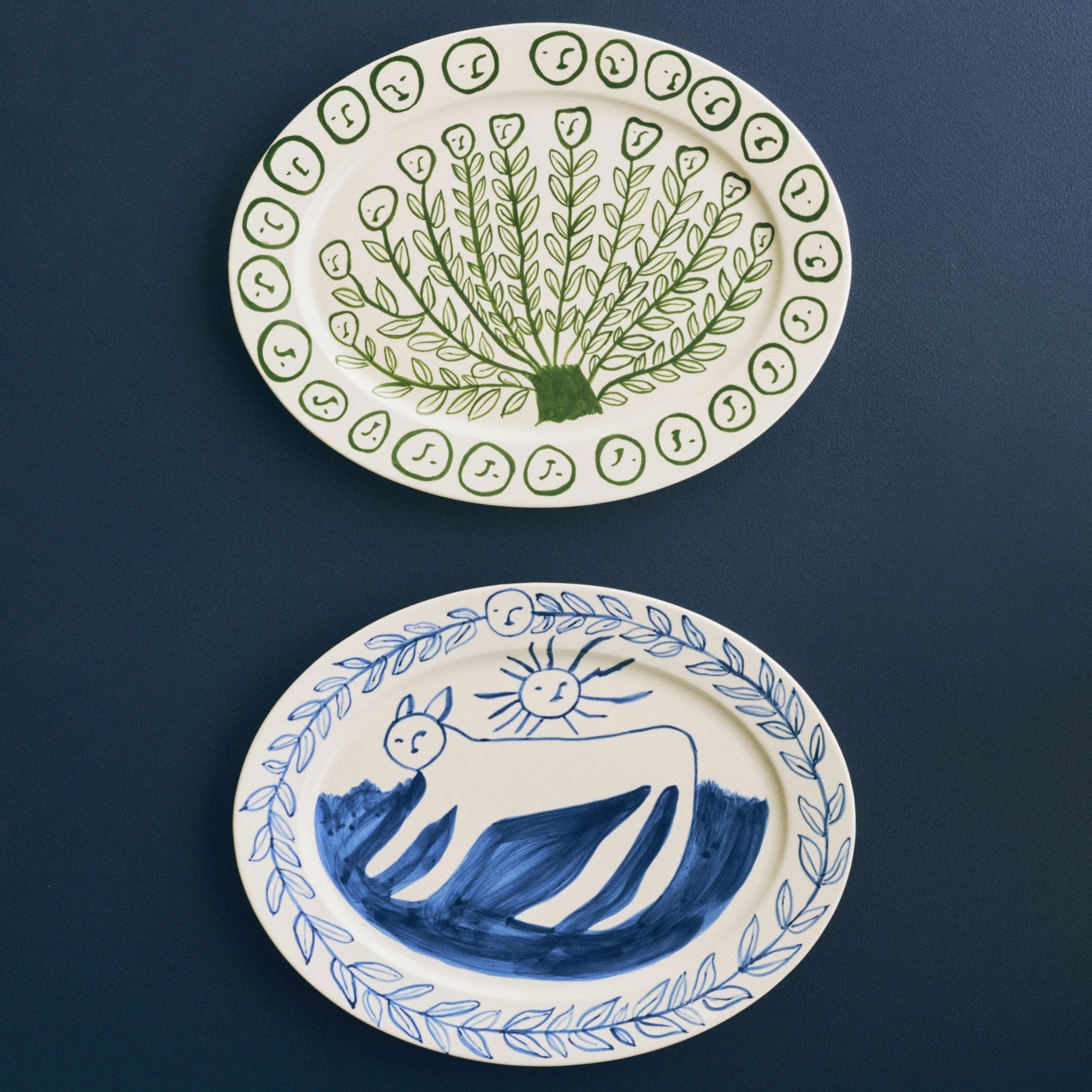 HAY x Emma Kohlmann - La Pittura Ø36.5cm Serving Platters in Olive grove and Charlotte against a dark blue background