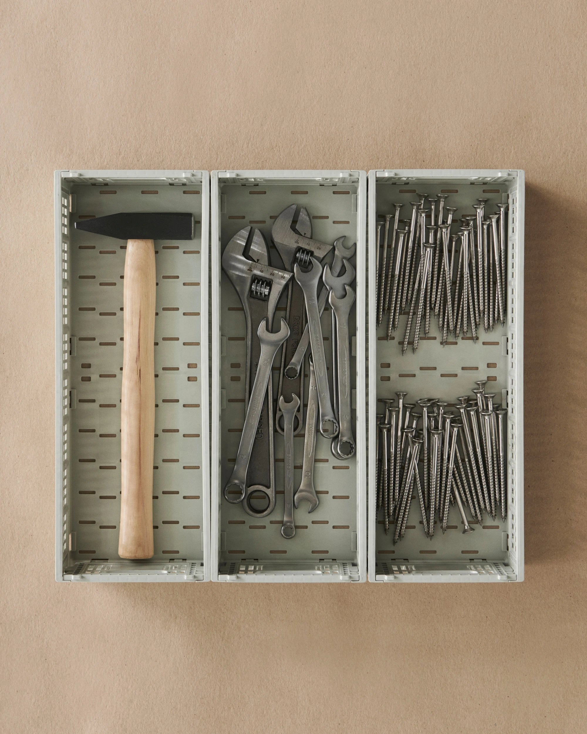 HAY colour crates perfectly storing various tools including a hammer, wrenches, and screws on a beige background | Lifestory