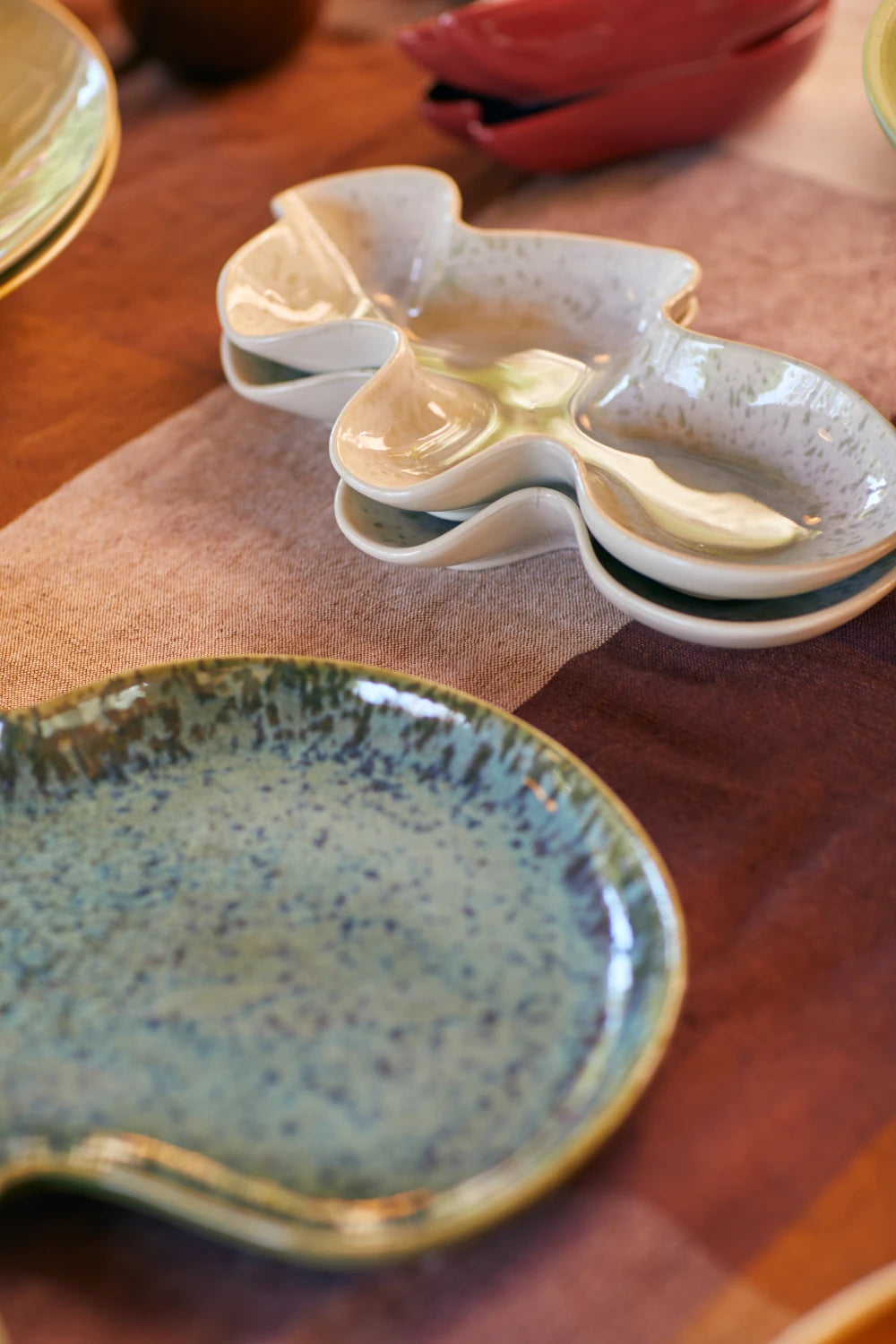 HKLIVING Ceramic Shell Serving Bowl in Oyster on a tablecloth next to other ceramics from the collection