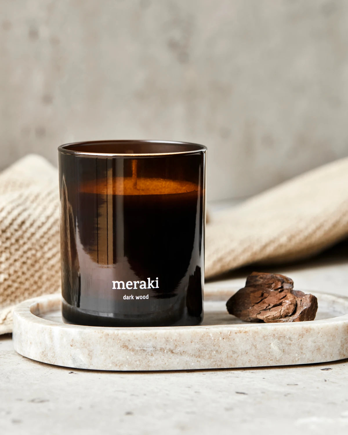 Meraki Large Scented Candle with Dark Wood fragance. Brown glass jar on a marble tray