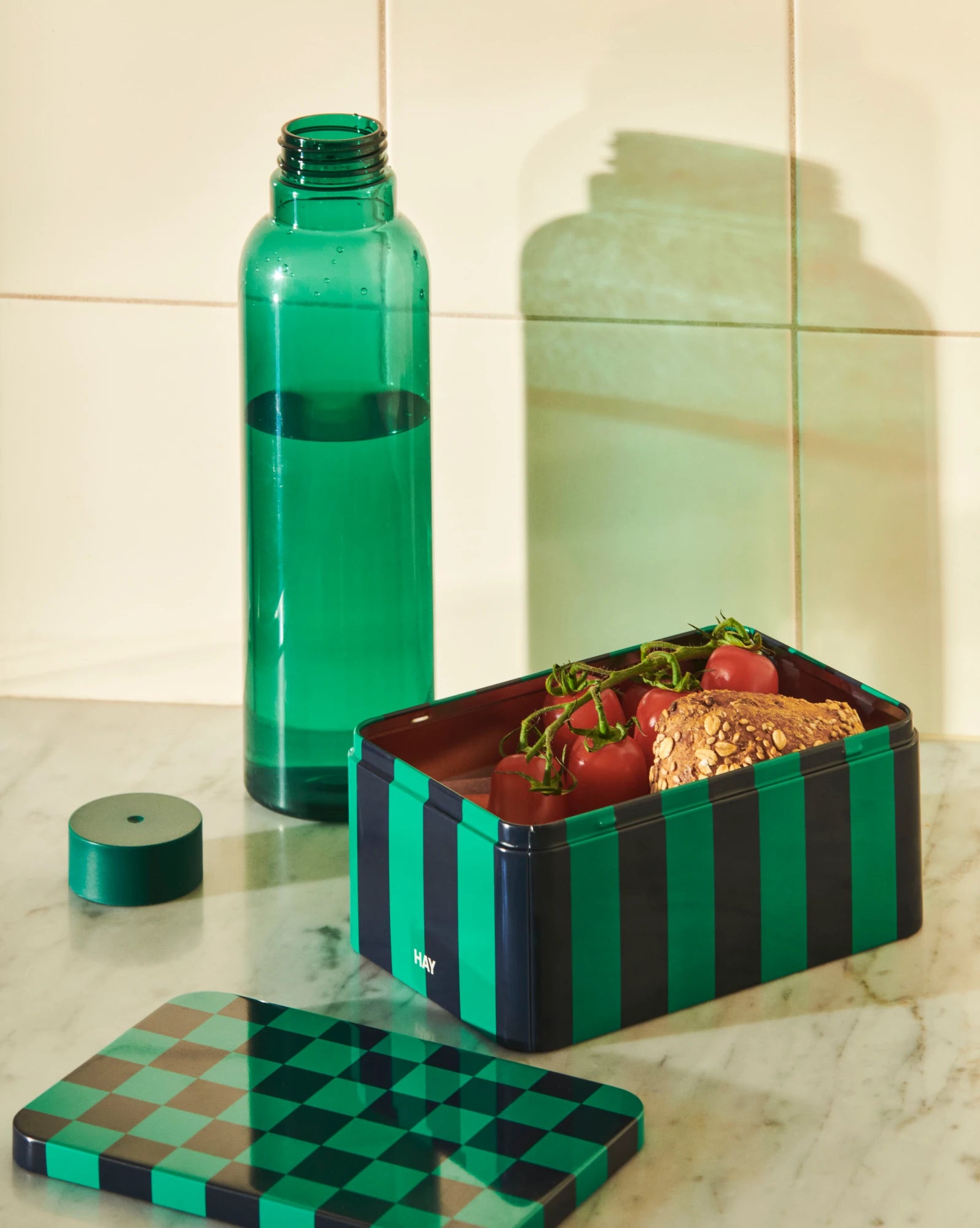Miz Water Bottle 0,72 litre in dark green by HAY on a kitchen counter with a small dark blue and green tin container | Lifestory