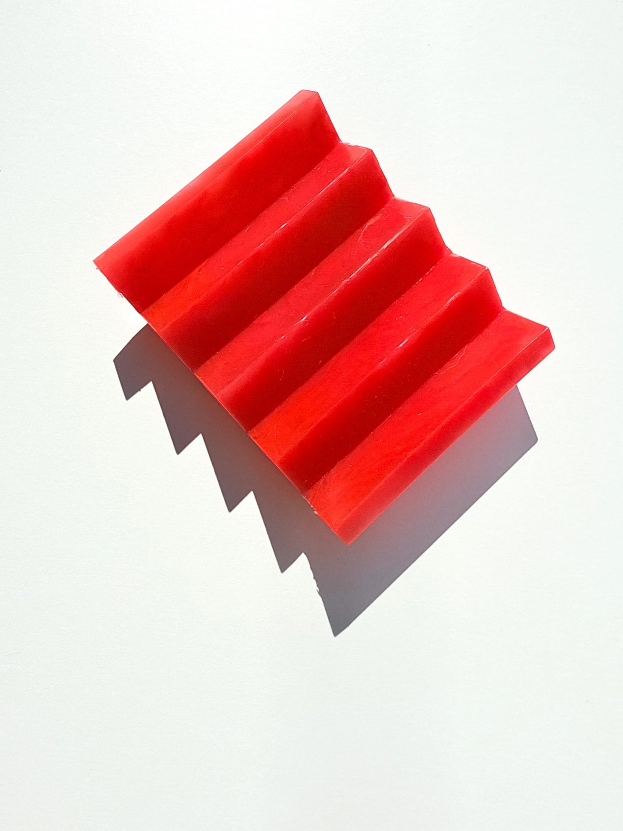 A red zig zag soap dish on a white background