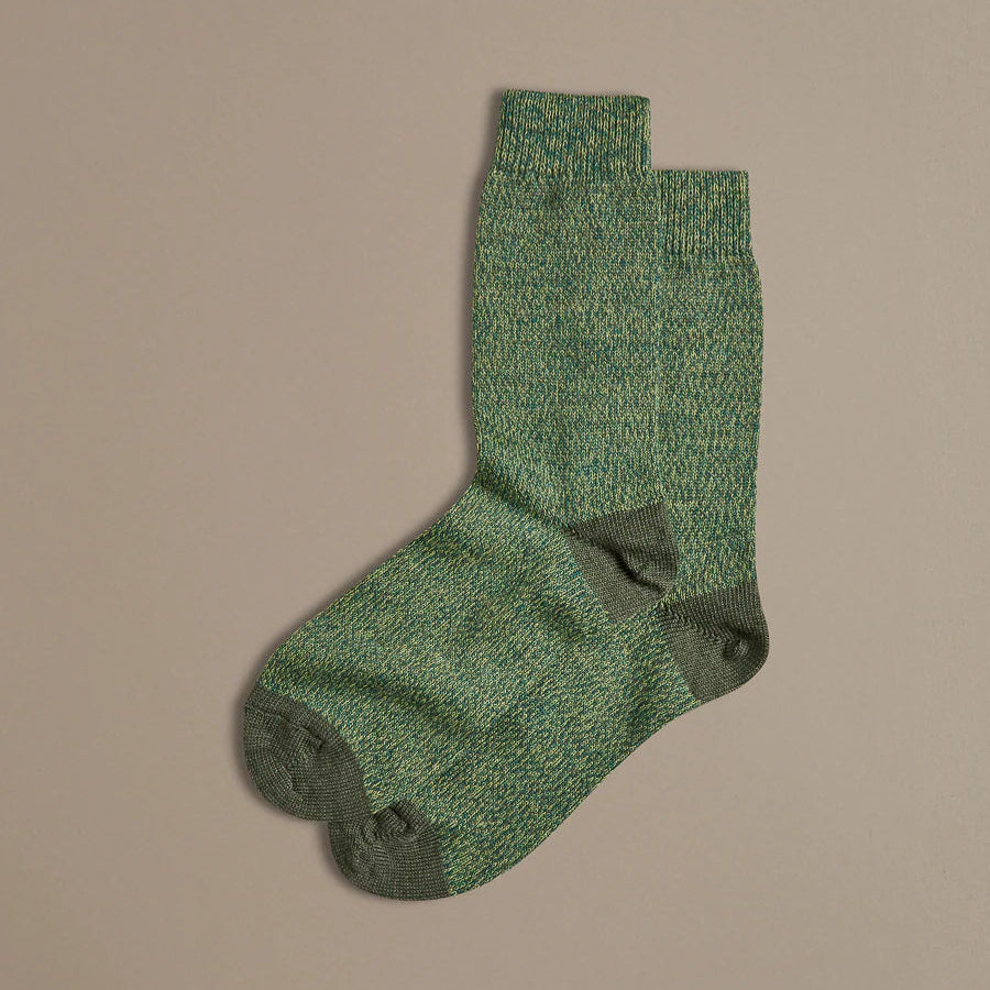 Green socks with a subtle pattern on a beige background