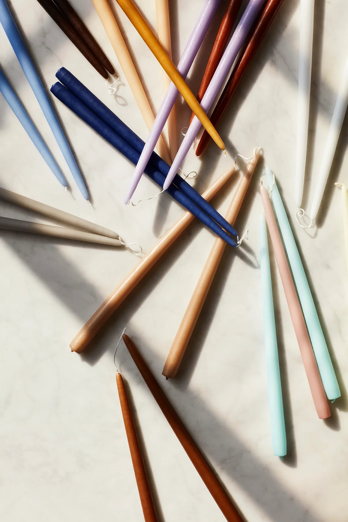 Broste Copenhagen Set of 4 Smooth Taper Candles (Ø2.2 x H38 cm) context shot with other colour ways on a flat surface