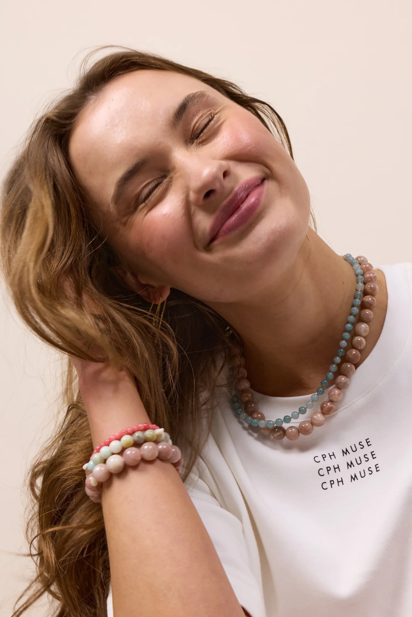 Woman wearing Soï Copenhagen Hailey necklace with Aquamarine crystal beads in 18k gold