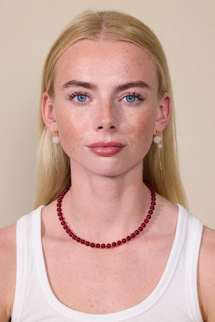 Woman wearing Soï Copenhagen Hailey necklace with Red Jade crystal beads in 18k gold