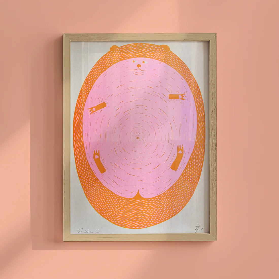 Framed artwork of a pink and orange circular hedgehog on a peach wall