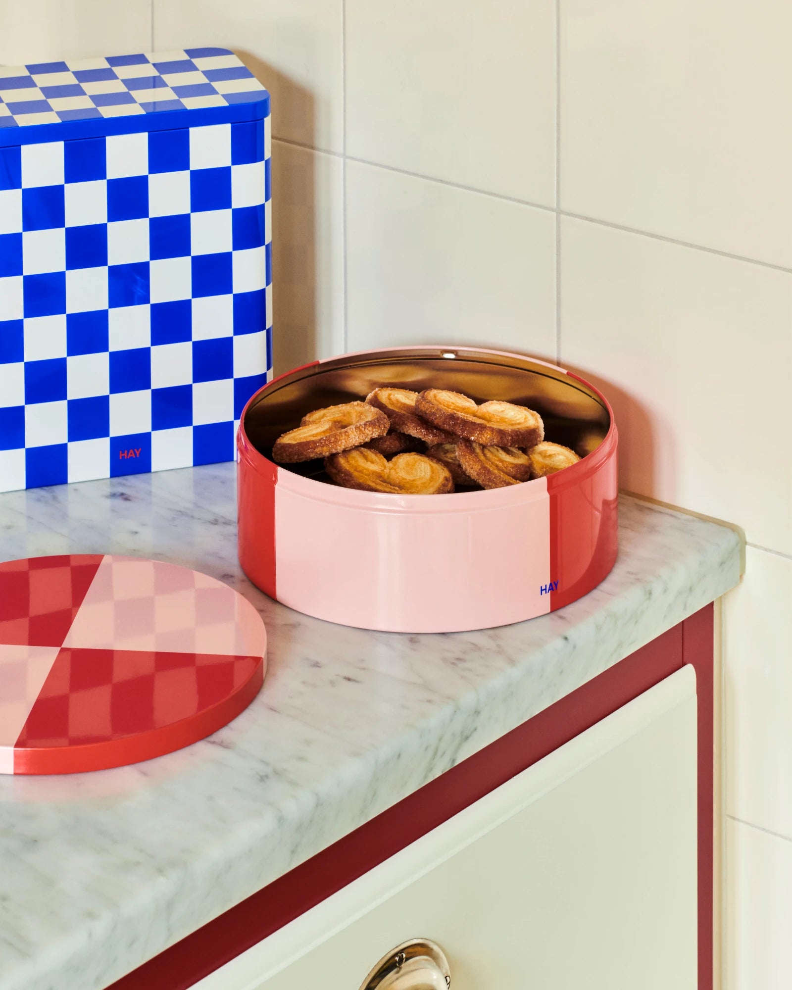 Round Tin Container in Red and Light pInk by HAY full of biscuits on a counter top | Lifestory