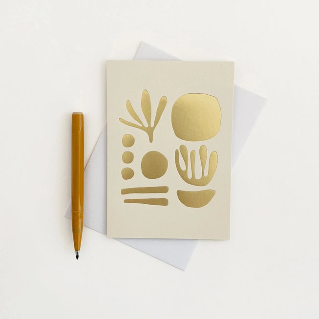 Tom Pigeon seaweed card featuring a brass foiled geometric design on a mist white background