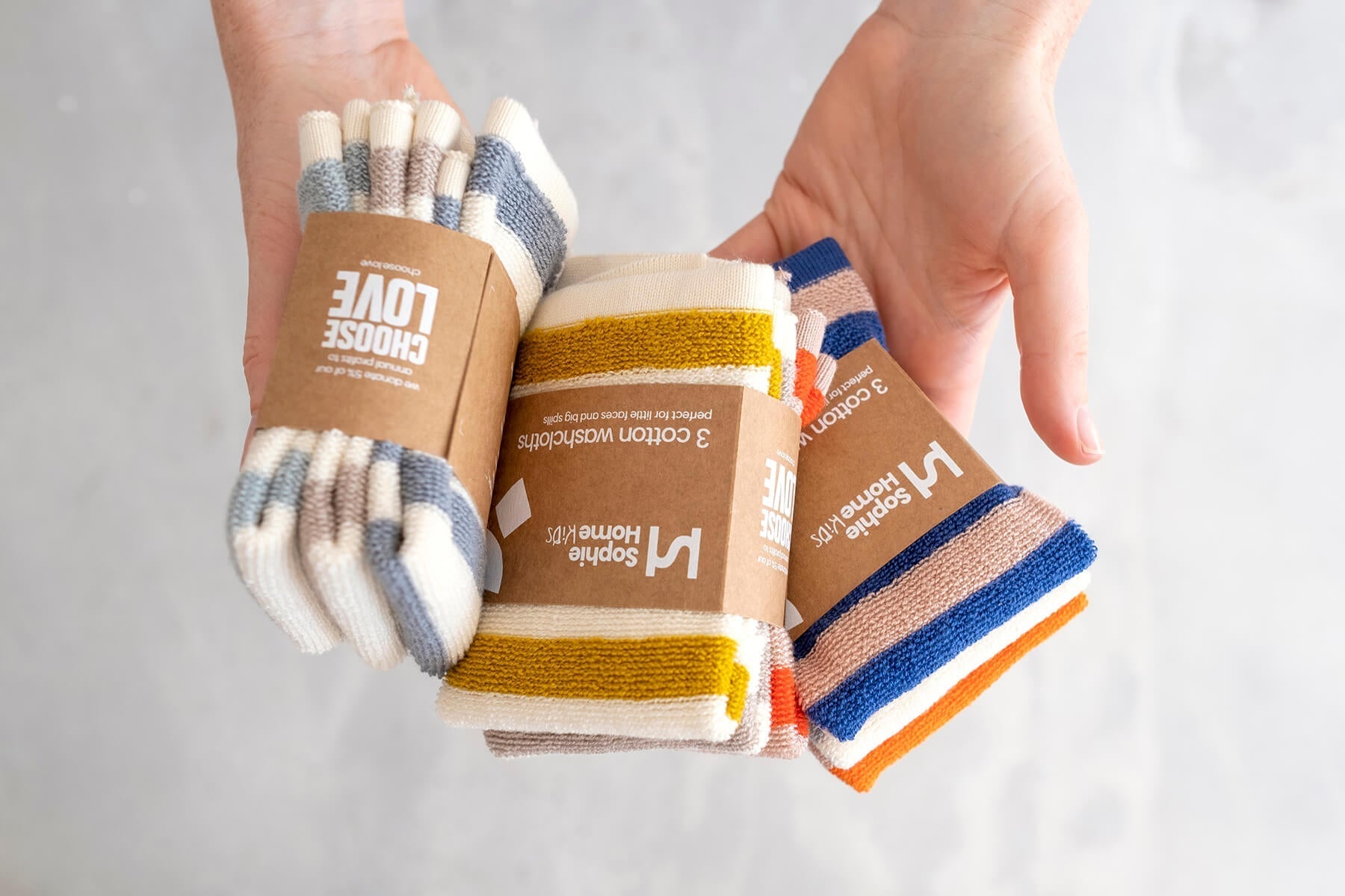 Hands holding 3 colourways of the Reusable Terry Washcloths by Sophie Home at Lifestory