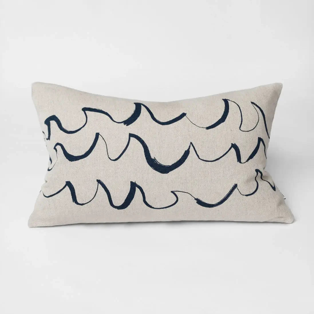A long cushion in natural linen with a minimal blue wave shaped brush stroke motif from Fine Little Day