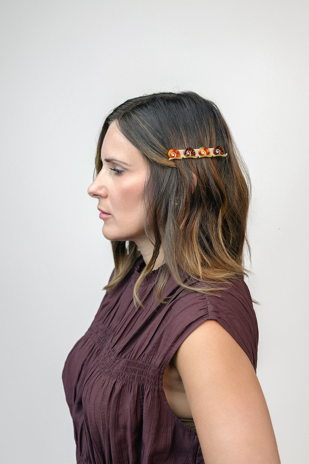 Winona Irene Escargot Snail Alligator Hair Clip being worn by a model with mid length brown hair