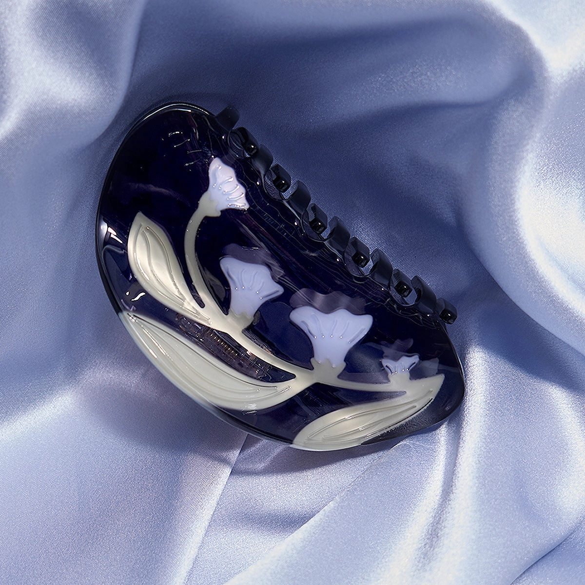 Black and white hair clip on a light blue fabric background