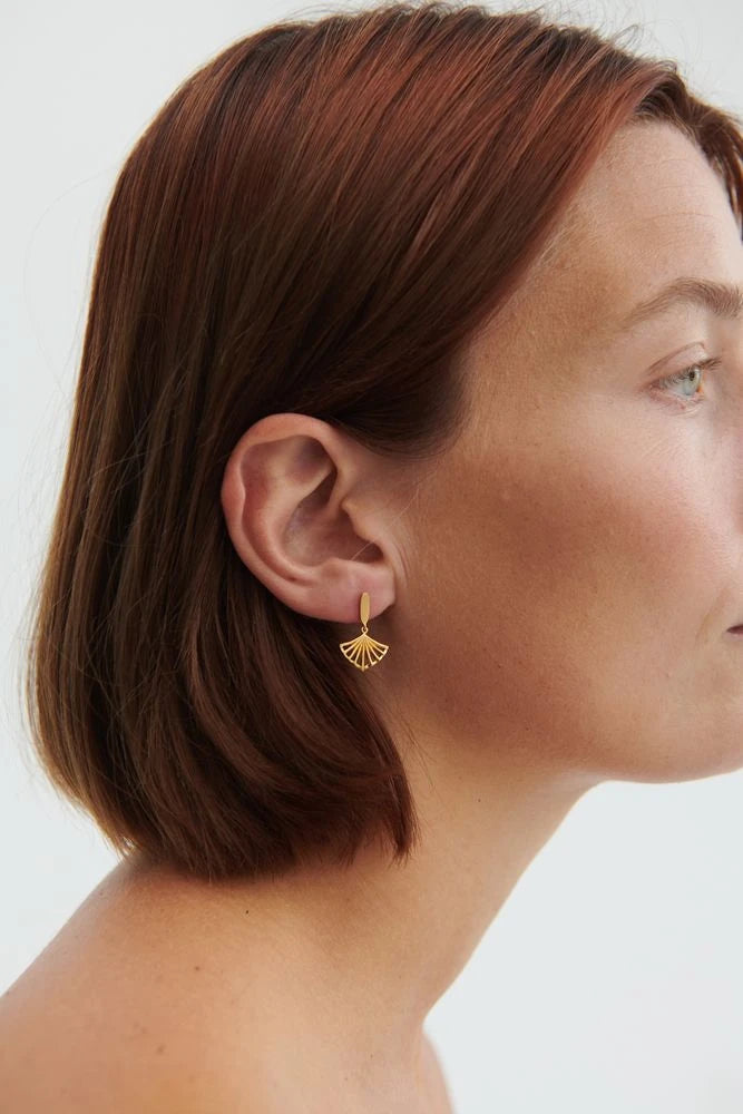 Ballerina Earrings in Gold-Plated Silver by Pernille Corydon on a white model with dark red hair and blue eyes against a cream background