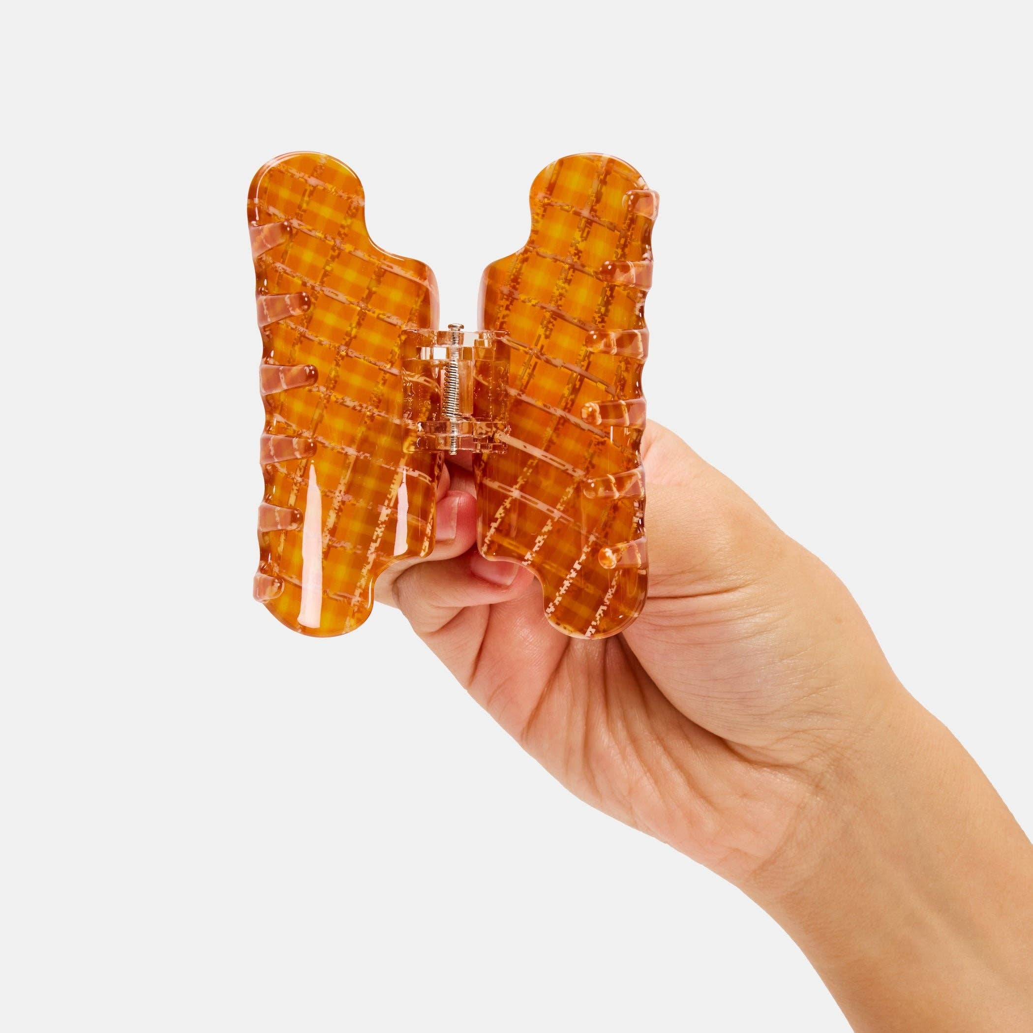 CHUNKS Baby Nimbus Hair Claw in Caramel Plaid being held open by a models hand