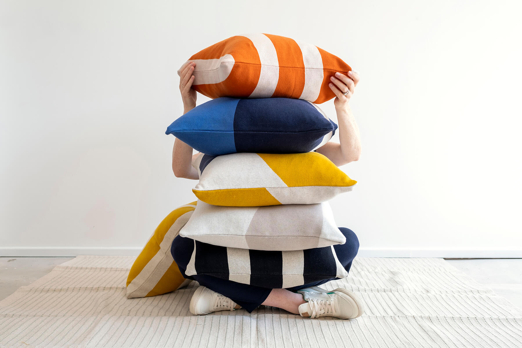 Sophie Home cushions stacked in front of a model