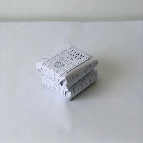 An off white background with 2 packaged Dog Soaps from Farm Soap Co
