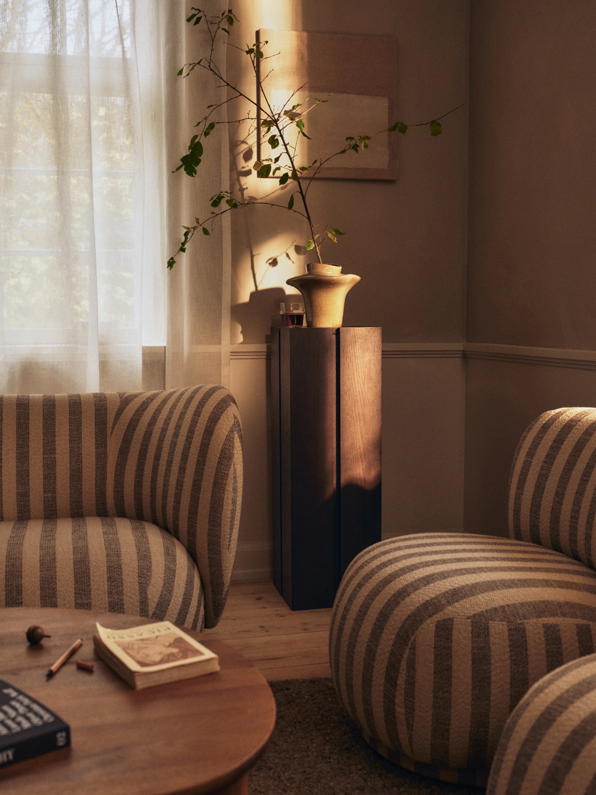 Cozy living room with striped armchairs and a wooden table.