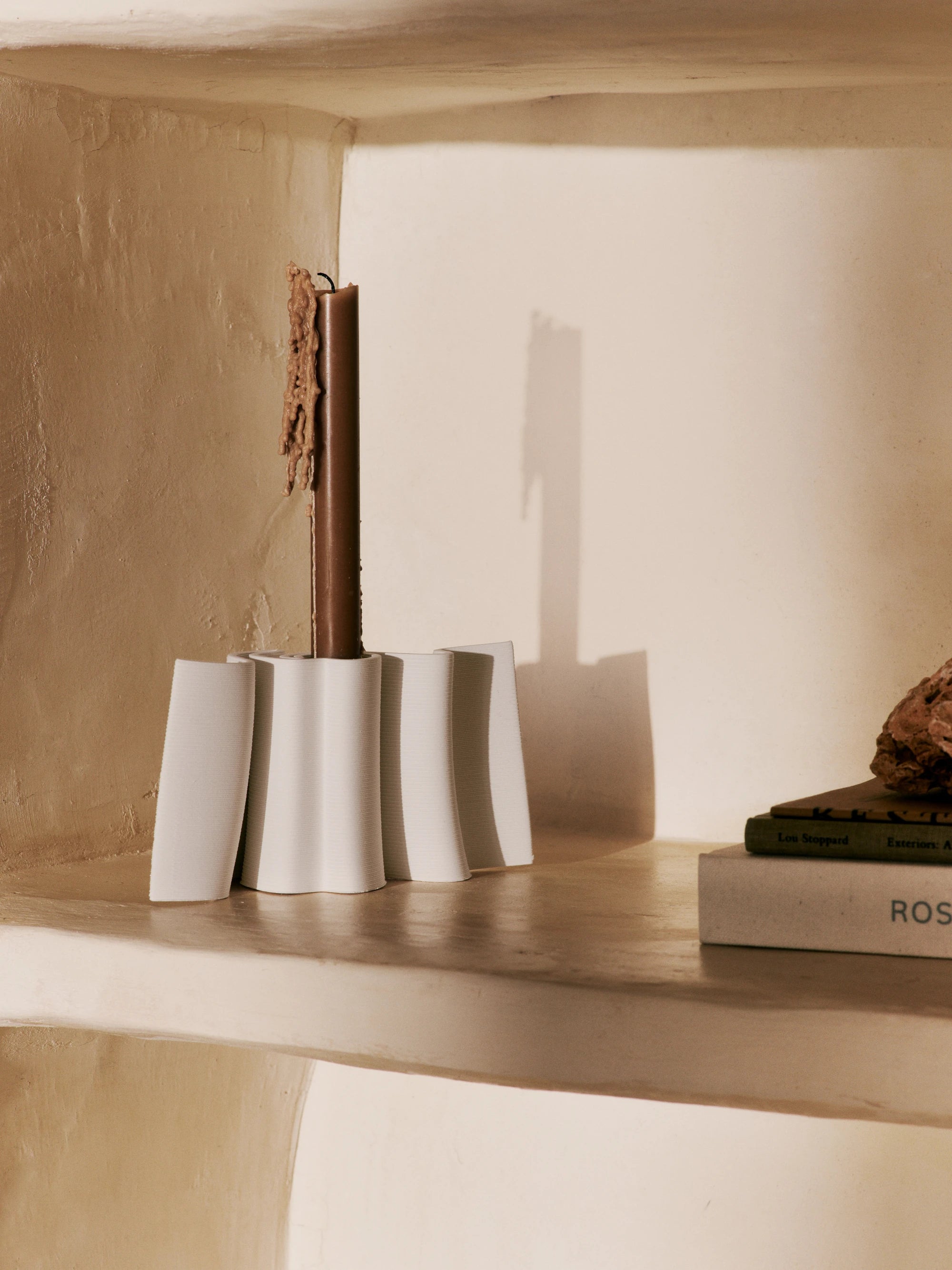 Ferm Living Dedali Candle Holder in Off-White 3D Printed Stoneware with brown partially burned candle on a shelf