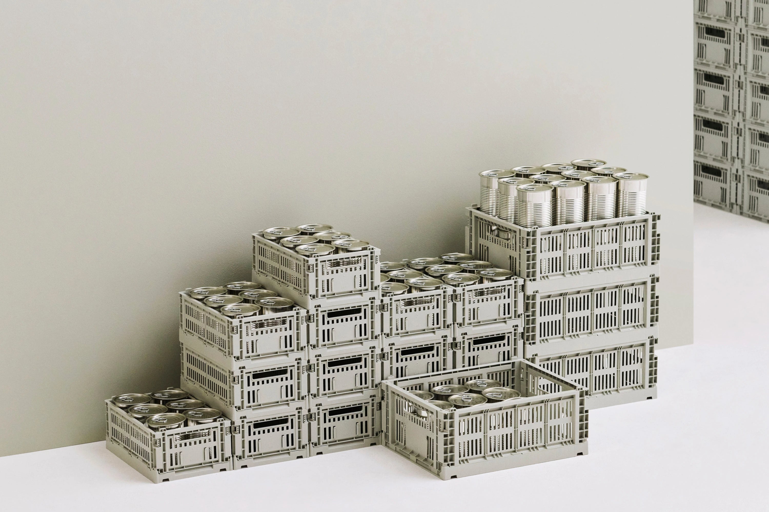 Stacks of HAY colour crates with cans on a white surface and light gray background | Lifestory