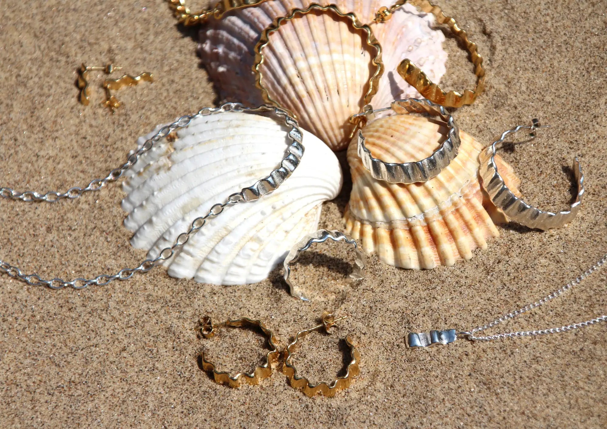 Multiple Hannah Bourn Jewellery products on shells on a beach
