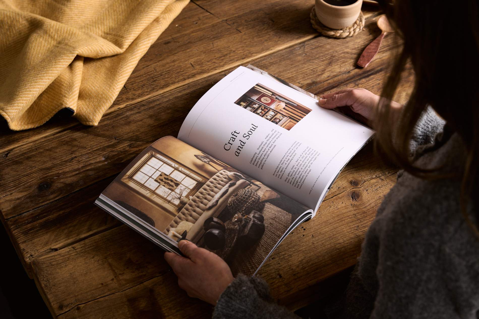 Hidden Scotland Magazine Issue 10 held open in hands on a wooden table at Lifestory Store