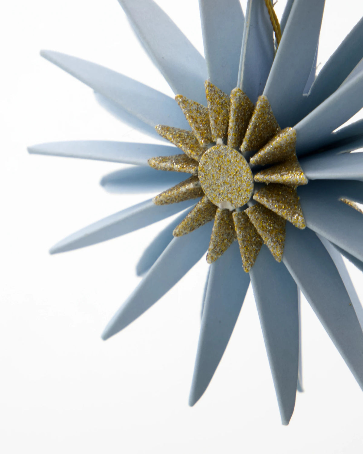 Decorative star ornament with gold center and blue rays on a white background