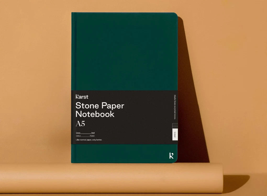 Karst A5 Stone Paper Hardcover Notebook - context image with forest green cover and bellyband
