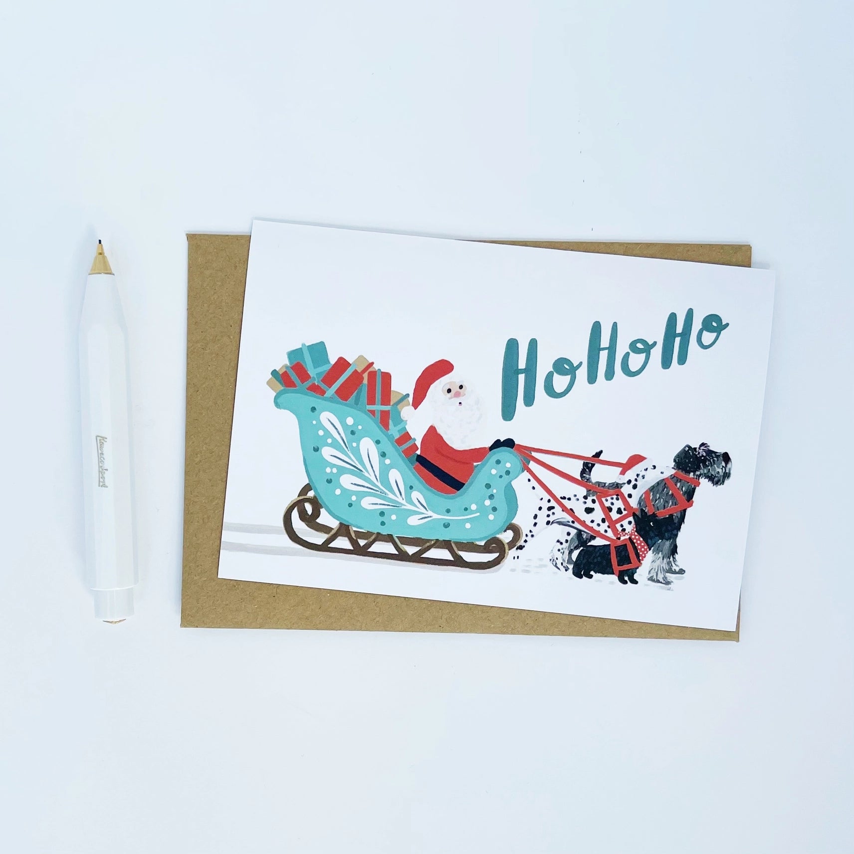 Greeting card with Santa Claus in a sleigh and dog, featuring the word 'HoHoHo', on a white background.
