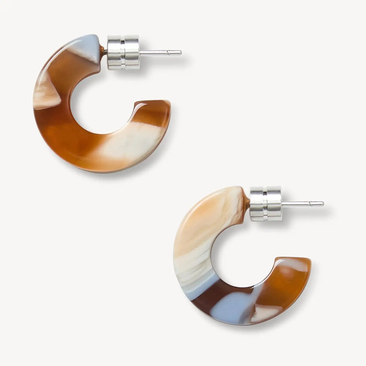 A pair of C-shaped hoop earrings with a marbled agate pattern in brown, cream, and light blue, featuring silver-tone posts on a light gray background.