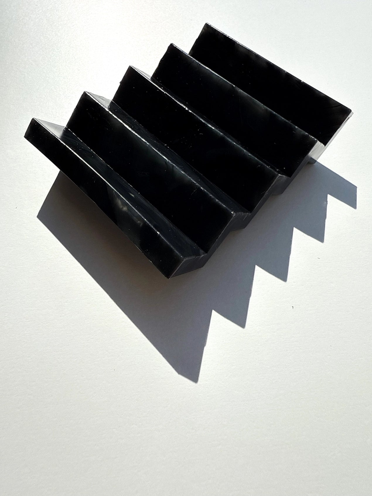 A black zig zag soap dish on a white background
