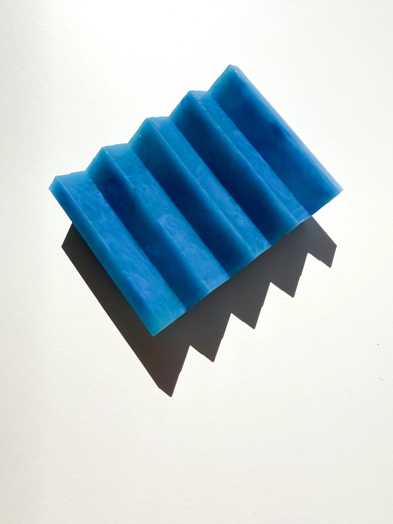A blue zig zag soap dish on a white background