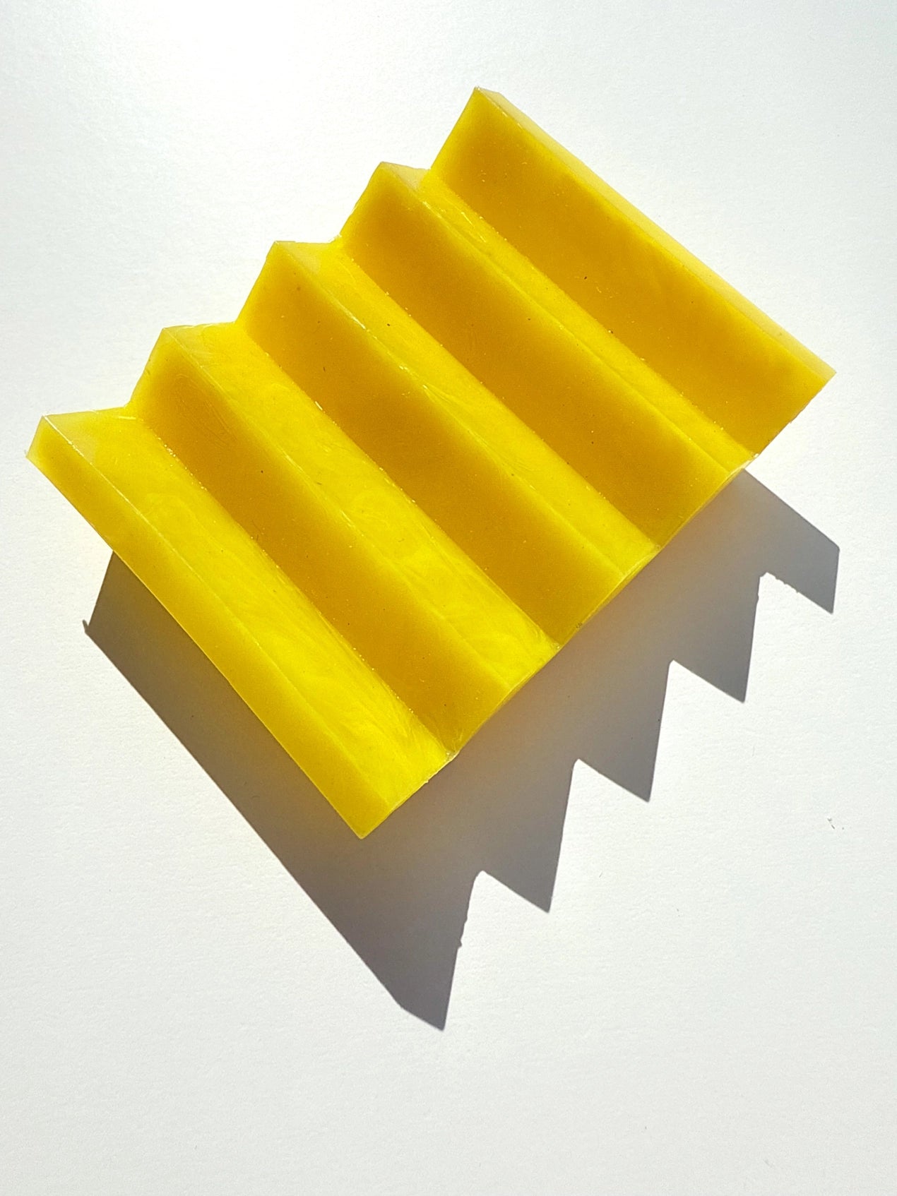 A yellow zig zag soap dish on a white background