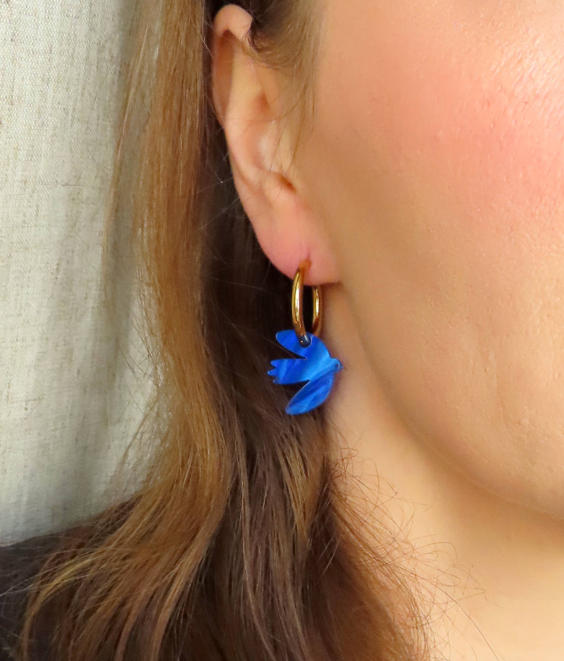 Niemalsmehrohne Dove Hoop Earrings in Ink Blue Acrylic being worn y a white model with brown hair - close up view