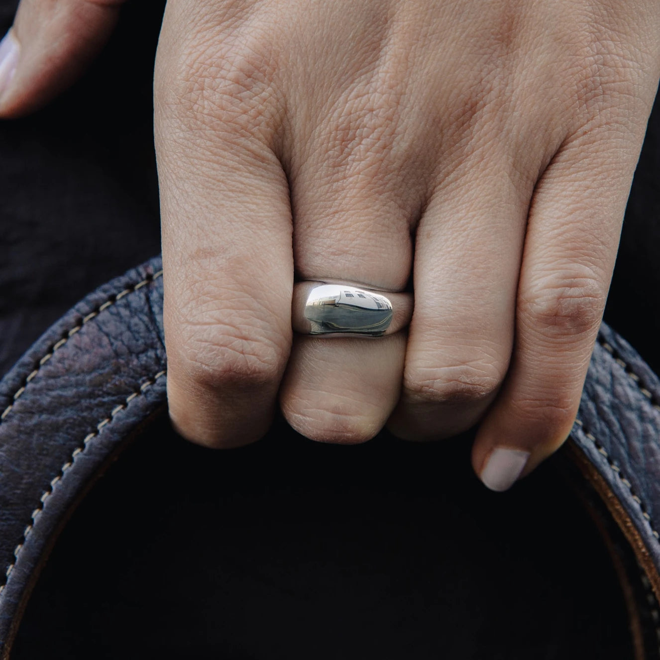 Dome Ring with Water Resistant Silver Plating by Nordic Muse being worn by a hand holding a leather bag strap