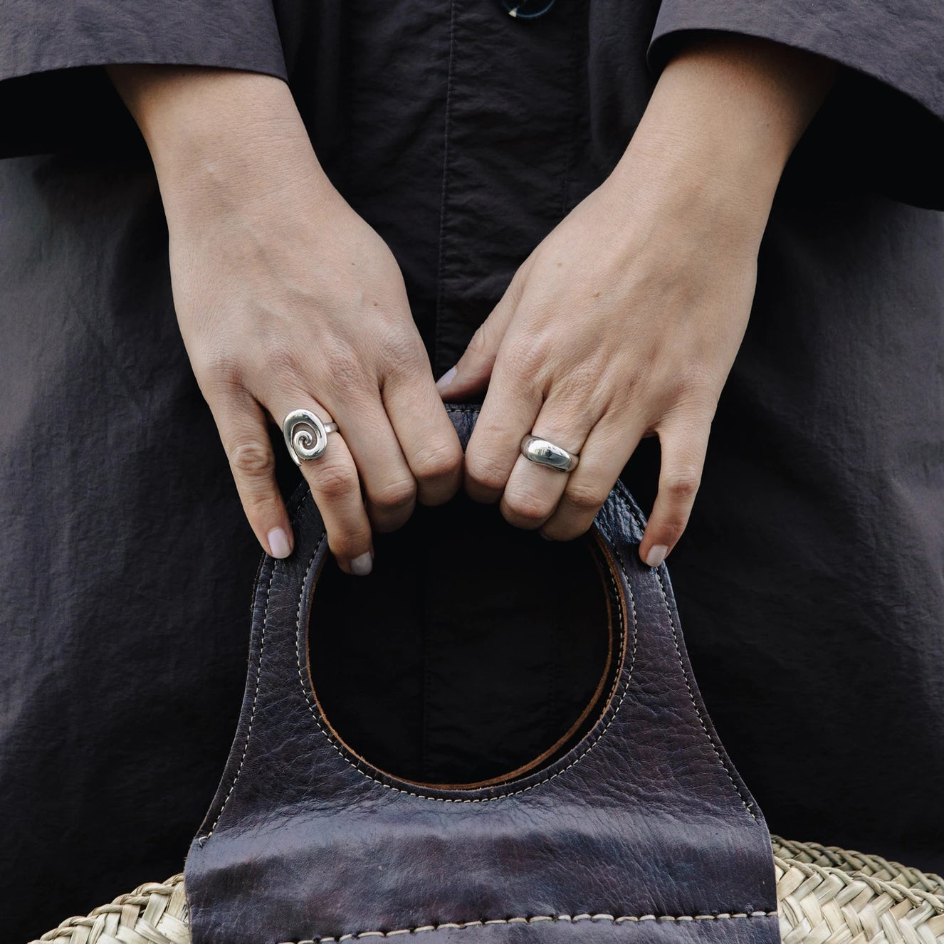 Dome Ring with Water Resistant Silver Plating by Nordic Muse being worn by a hand holding a leather bag strap