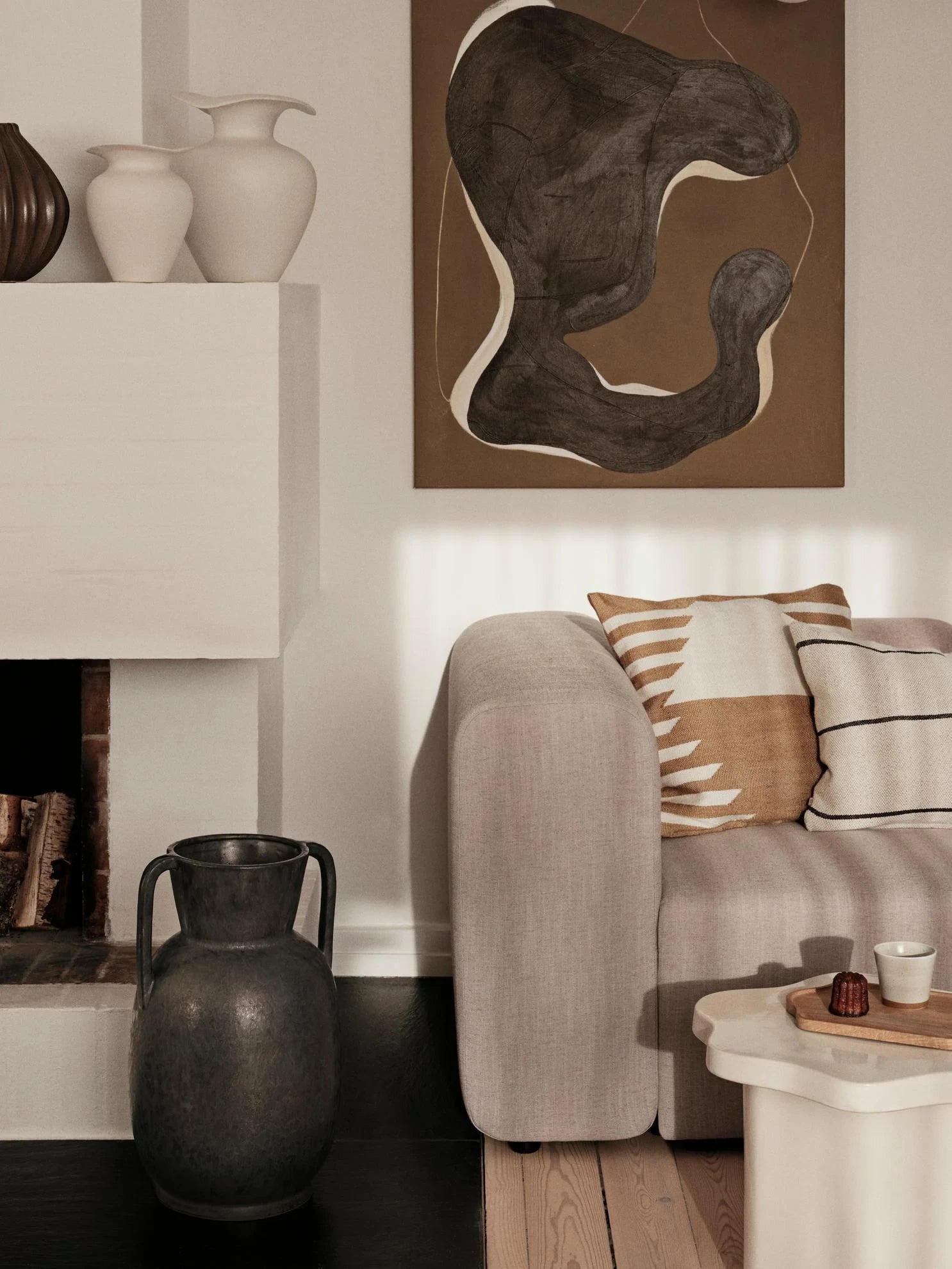 Broste Copenhagen Off-white Glazed Stoneware M Florentina Vase on a high shelf next to other vases in a neutrally decorated living room