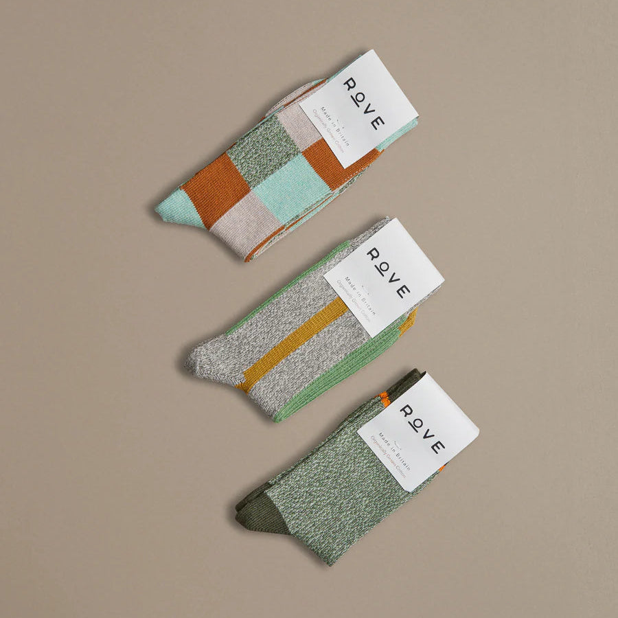 Three pairs of socks with color-blocked patterns and 'ROVE' labels on a beige background