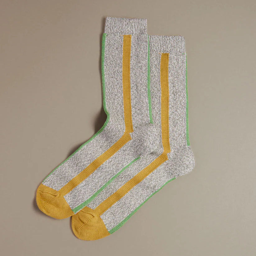 Pair of socks with yellow and green stripes on a beige background