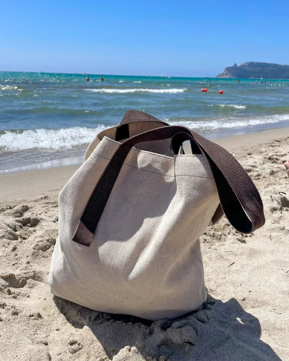 Beige Shangies tote bag on a sandy beach with ocean and clear sky in the background | Lifestory