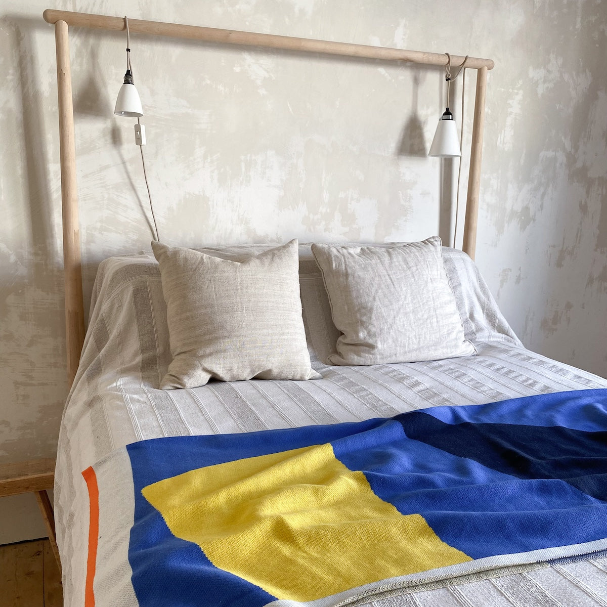 Orbi Cotton Throw in Cobalt by Sophie Home in context on top of a linen bedding set